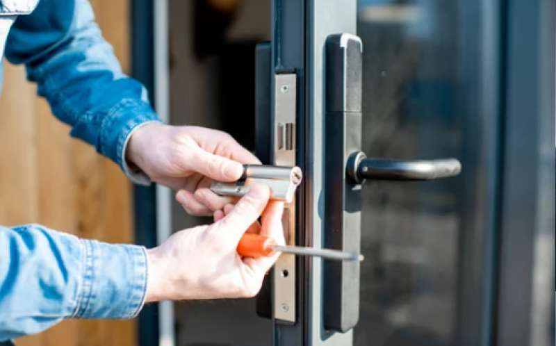 Técnico a reparar o mecanismo de uma porta
